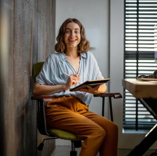 Kvinna som arbetar på en iPad och ler på kontor